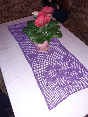 Lila gehäkelter Filet-Tischläufer mit Blumenmotiv und Topfblumen in der Mitte