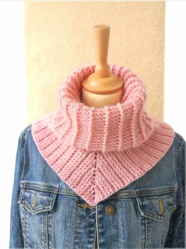 Rosa gehäkelter Kragenschal mit breitem Rollkragen auf Schaufensterpuppe über Jeansjacke
