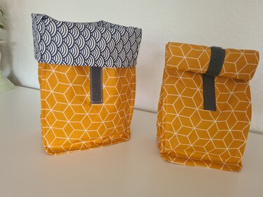 Zwei gelbe Stoff-Brottaschen mit weißem geometrischem Muster, Umschlag und grauer Verschlusslasche