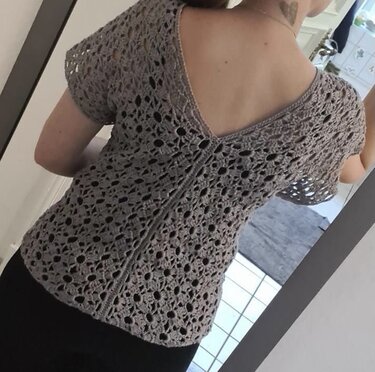 Rückenansicht eines gehäkelten Damen-Tops mit floralem Lochmuster, kurzer Ärmel und V-Ausschnitt