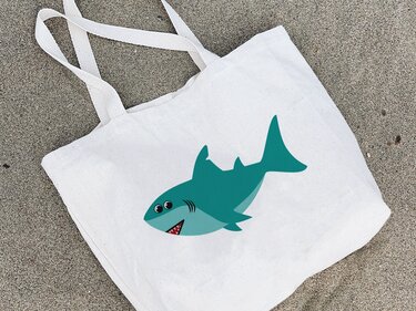 Stofftasche mit mittig platziertem, einfarbigem Hai-Motiv auf Sand