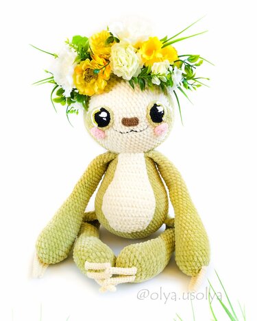 Gehäkeltes Amigurumi-Faultier in Grün und Weiß mit Blumenkranz