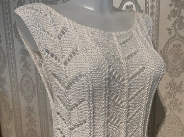 Weißes ärmelloses Damen-Stricktop auf Büste mit Ajour- und Strukturmuster