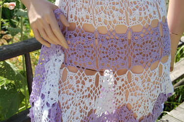 Gehäkeltes Kleid auf Mannequin, weiß und lila mit filigranen Blumenquadraten