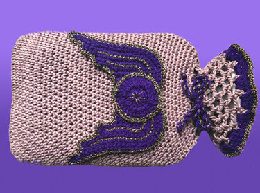 Gehäkelter Wärmflaschenbezug in Rosa und Lila mit Flügel-Applikation und goldenen Glitzerakzenten