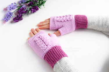 Two-tone lilac and magenta crocheted fingerless gloves with cable stitch, worn on hands