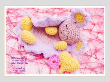Gehäkeltes Schmusetuch in Lila und Gelb mit Mäusekopf, Herz und Blüte auf rosa Untergrund.