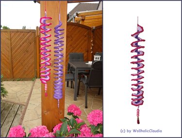 Zwei gehäkelte Spiralanhänger in Pink und Lila mit Perlen und Quaste an Holzbalken, Einzelansicht auf weißem Hintergrund