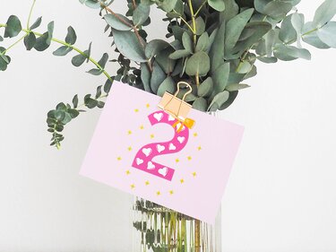 Plottmotiv Zahl 2 mit Herzfüllung auf rosa Karte vor Eukalyptus