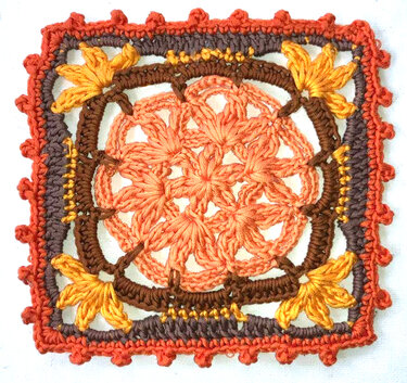 Gehäkeltes quadratisches Motiv mit zentraler Blüte in Orange, braunem Rahmen und gelbem Blattdekor