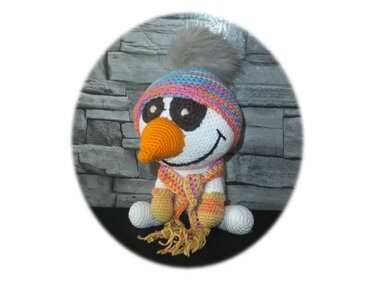 Gehäkelter Schneemann-Amigurumi mit bunter Mütze und Schal