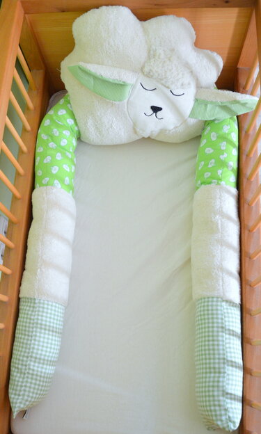Babybett mit Schäfchen-Kopfkissen und gepolstertem Nestchen in Grün und Weiß