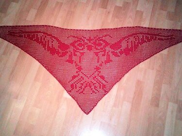 Rotes Dreieckstuch, gehäkelt mit einem durchbrochenen Muster, auf einem Holzboden