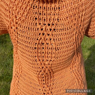 Rückenansicht einer orangefarbenen, gehäkelten Damenjacke mit kurzem Ärmel und mittigem Zopfmuster