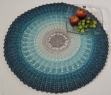 Rundes gehäkeltes Deckchen in Blau‑Grau mit Glasschale und Obst