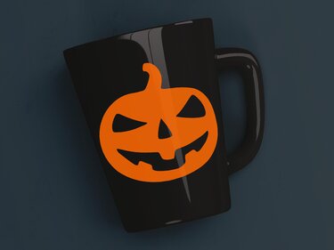 Schwarze Tasse mit einfarbigem orangefarbenem Kürbisgesicht Plottmotiv