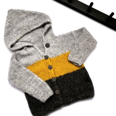 Gestrickte Baby-Kapuzenjacke grau-gelb-dunkelgrau liegend mit Knopfleiste