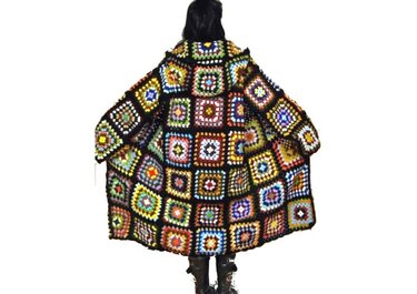 Rückenansicht einer langen, gehäkelten Jacke aus bunten Granny-Squares mit schwarzer Umrandung