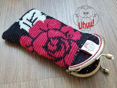 Gehäkeltes schwarzes Etui mit roter Rose und goldfarbenem Bügelverschluss