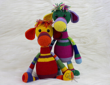 Zwei gehäkelte, gestreifte Amigurumi-Figuren in bunten Farben auf weißem Hintergrund