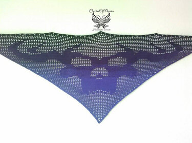 Gehäkeltes Dreieckstuch mit Totenkopf-Motiv und Ombré-Farbverlauf von Dunkelblau zu Lila.