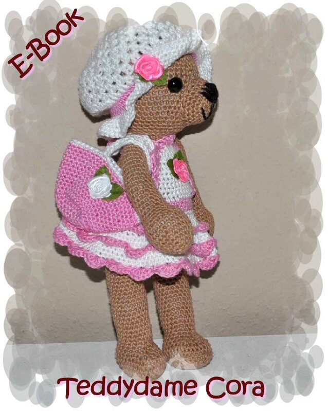 Gehäkelter brauner Teddybär mit rosa-weiß gestreiftem Kleid, weißem Hut und kleiner rosa Tasche.