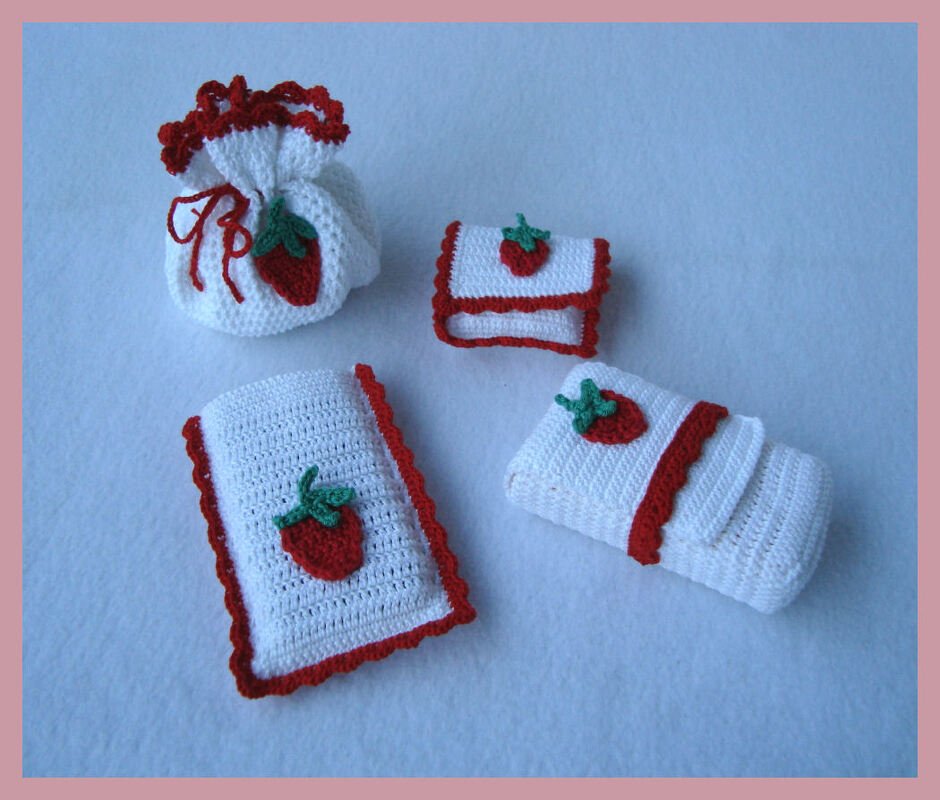 Kompaktes Set aus gehäkelten Säckchen, Täschchen und Etuis mit Erdbeer-Applikationen