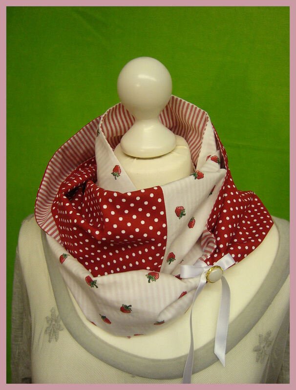 Reversibler Loop-Schal rot-weiß mit Erdbeeren, Punkten und Streifen auf einer Schneiderpuppe.
