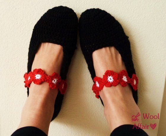 Schwarze gehäkelte Ballerinas mit kontrastierendem roten Blütenriemen