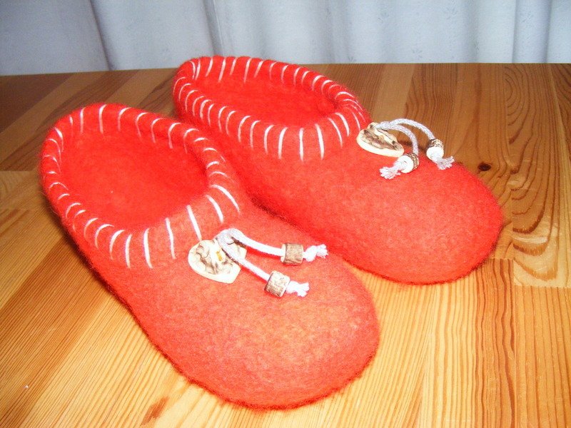 Paar rote gefilzte Hausschuhe mit Kordelverschluss und Perlen