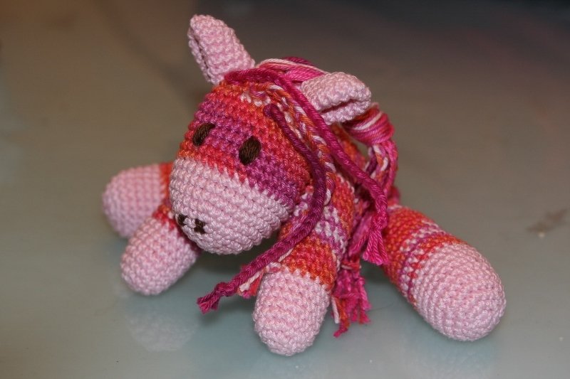 Gehäkeltes Amigurumi-Pferd in Rosa, Pink und Orange mit geflochtener Mähne