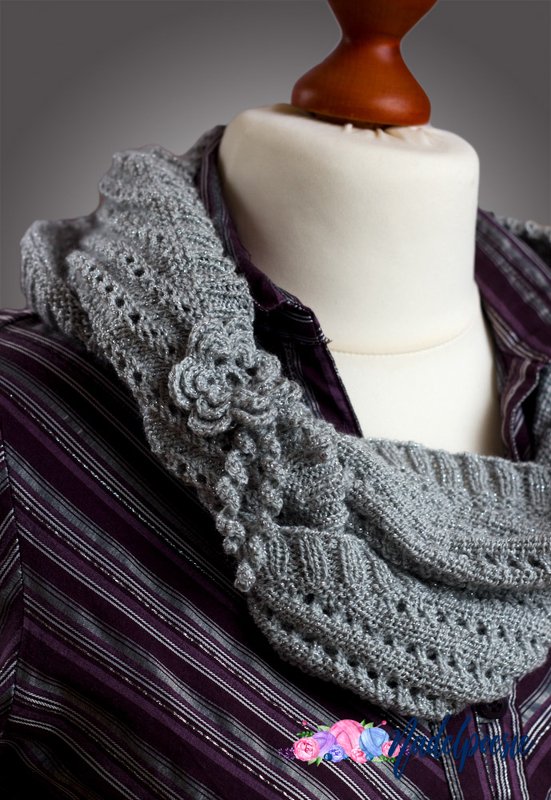 Grau gestrickter Loopschal mit Lochmuster und Zierblume auf Schneiderpuppe