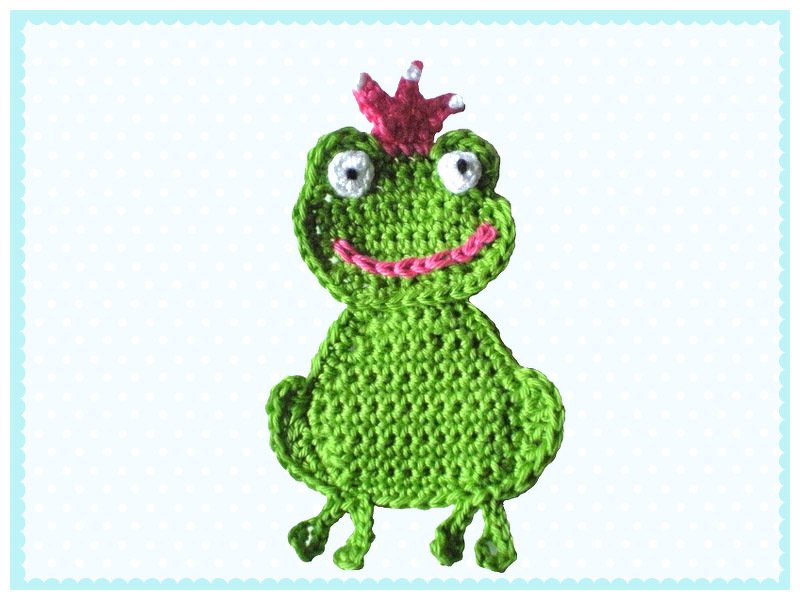 Grüne gehäkelte Frosch-Applikation mit rosa Krone und weißen Augen