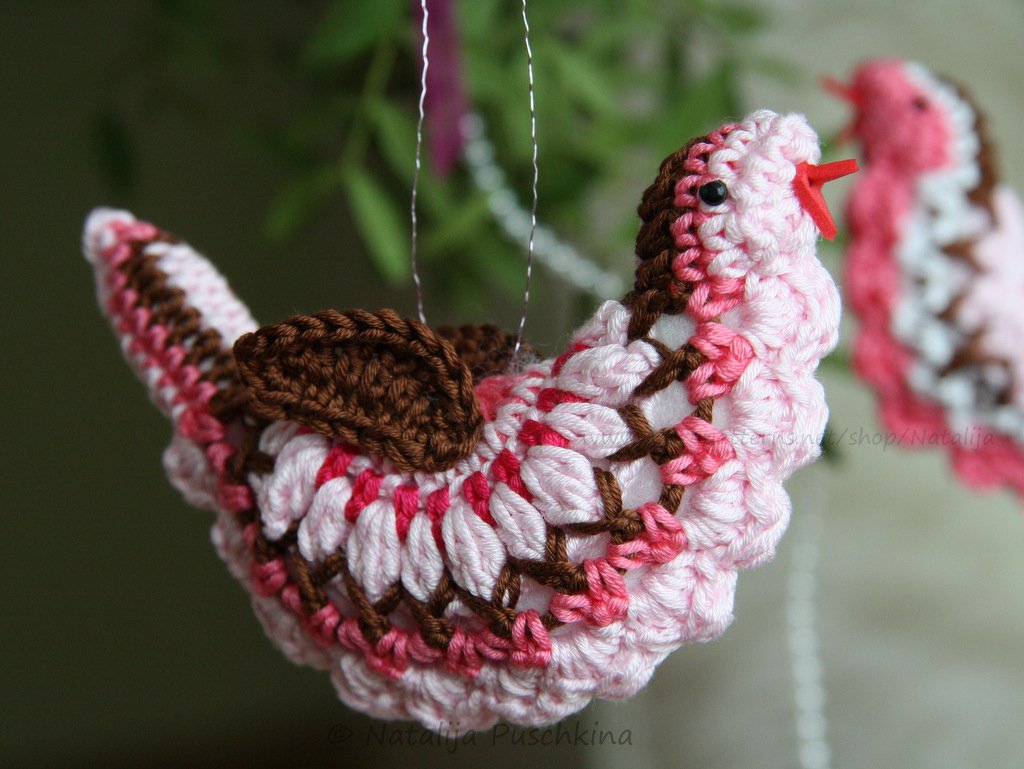 Gehäkelter Amigurumi-Vogel in Rosa, Weiß und Braun an Aufhängung, Nahaufnahme