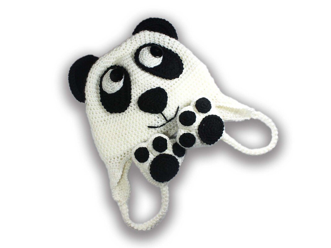 Weiße Häkel-Babymütze mit schwarzen Panda-Applikationen, Ohrklappen und Bindebändern