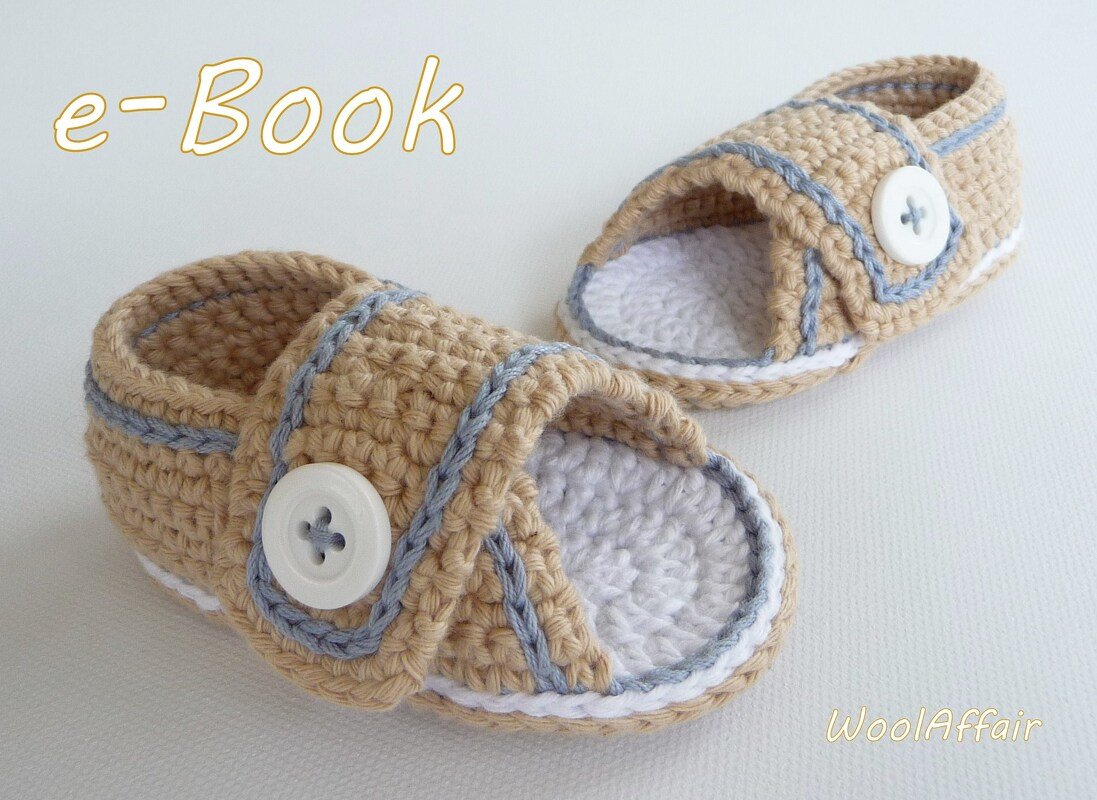 Beige gehäkelte Babysandalen mit Knopf, weiße Sohle und 'e-Book' Schriftzug