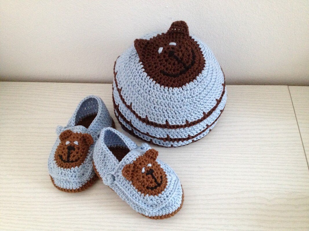 Hellblaue gehäkelte Babymütze und passende Babyschuhe mit braunen Bärenapplikationen