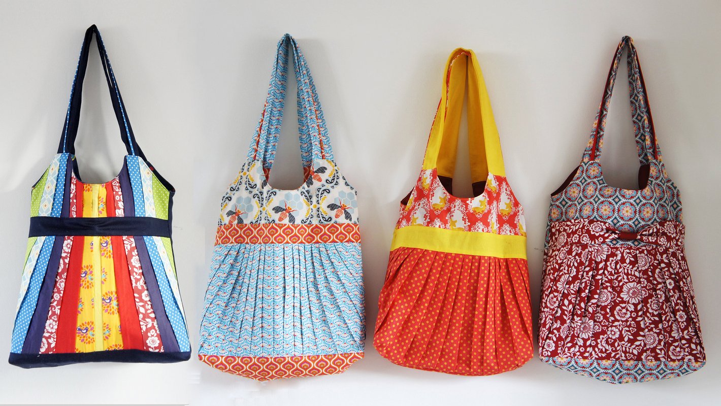 Vier bunte Stoff-Einkaufstaschen mit verschiedenen Mustern an einer Wand