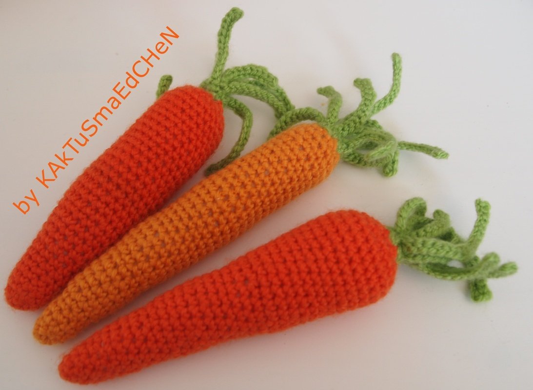 Drei Amigurumi-Karotten in Orange mit gehäkelten grünen Blättern