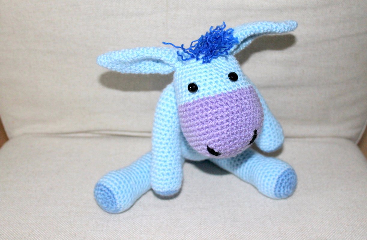 hellblauer gehäkelter Amigurumi‑Esel mit lila Schnauze und schwarzen Augen