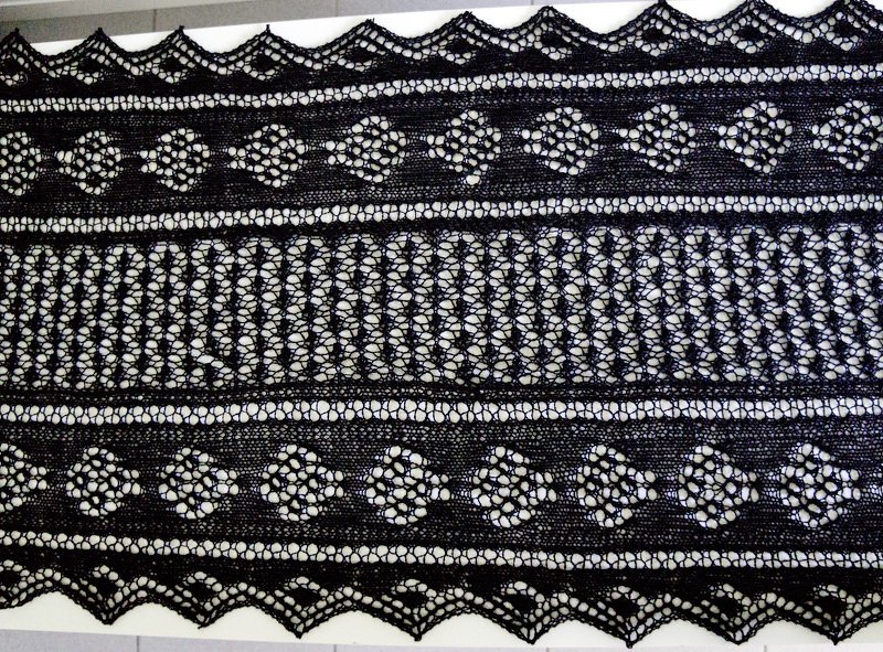 Detail: Lochmusterreihen, Rautenmotive und gezackte Bordüre eines schwarzen Lacetuchs