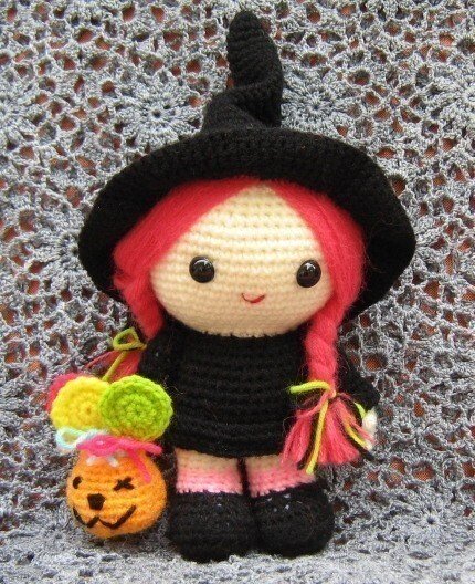 Gehäkelte Amigurumi-Hexe mit spitzem Hut, rosa Zöpfen und kleinem Kürbis-Täschchen