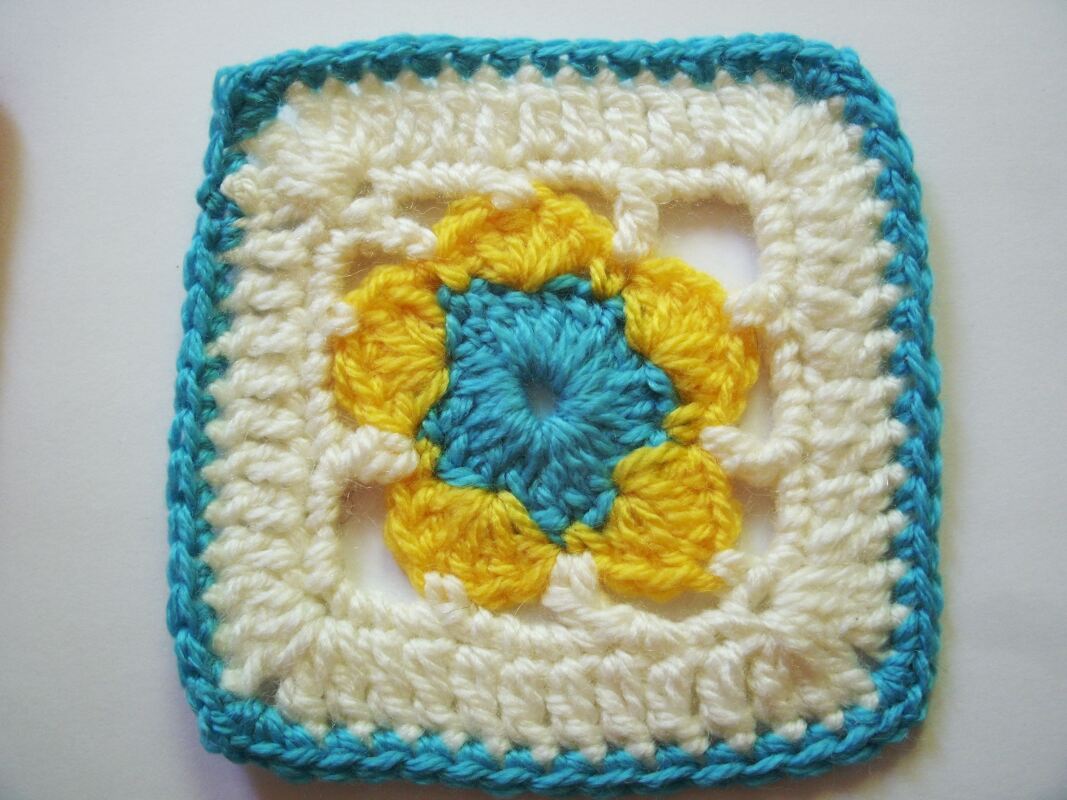 Gehäkeltes Granny
‑Square in Türkis, Gelb und Creme mit Blumenmuster