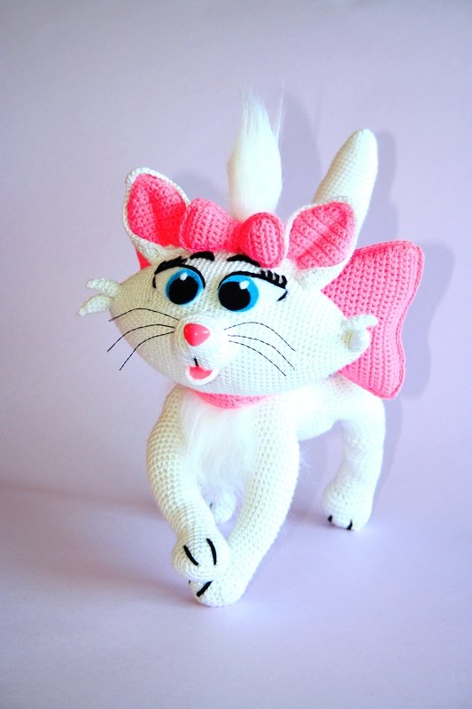 Gehäkelte Amigurumi-Katze weiß mit rosa Akzenten und blauen Augen