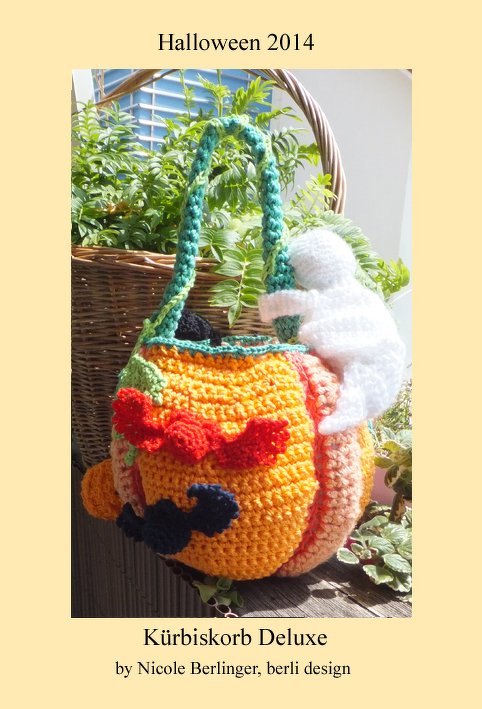 Gehäkelter orangefarbener Kürbiskorb mit grünem Henkel und weißem Geistanhänger