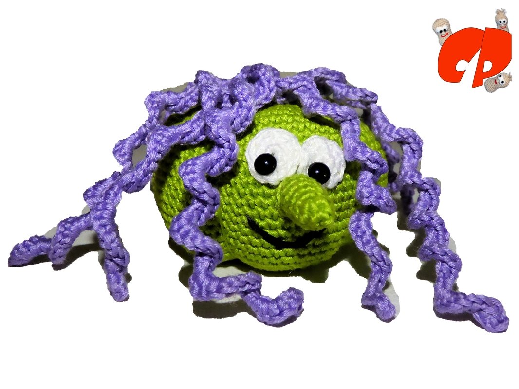 Grünes gehäkeltes Amigurumi mit großen weißen Augen, Knollennase und lila krausen Locken