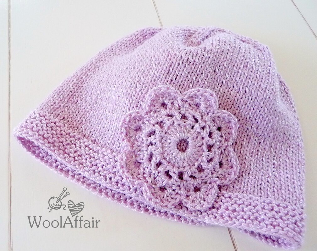 Helllila gestrickte Babymütze mit gehäkelter Blüte, Nahaufnahme