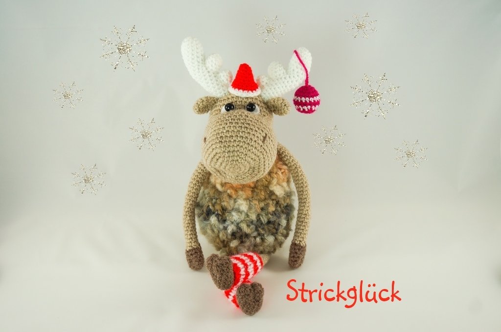 Gehäkeltes Amigurumi-Elch mit roter Weihnachtsmütze und gestreiften Socken vor hellem Hintergrund