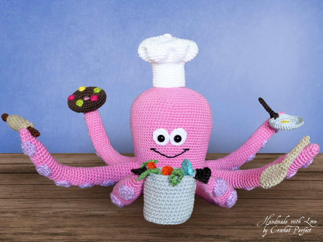 Rosa gehäkelter Oktopus-Amigurumi mit Kochmütze und gehäkelten Küchenutensilien