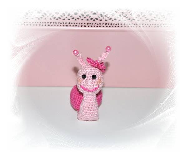 Kleine rosa Amigurumi-Schnecke mit Perlenfühlern und Schleife, Frontalansicht